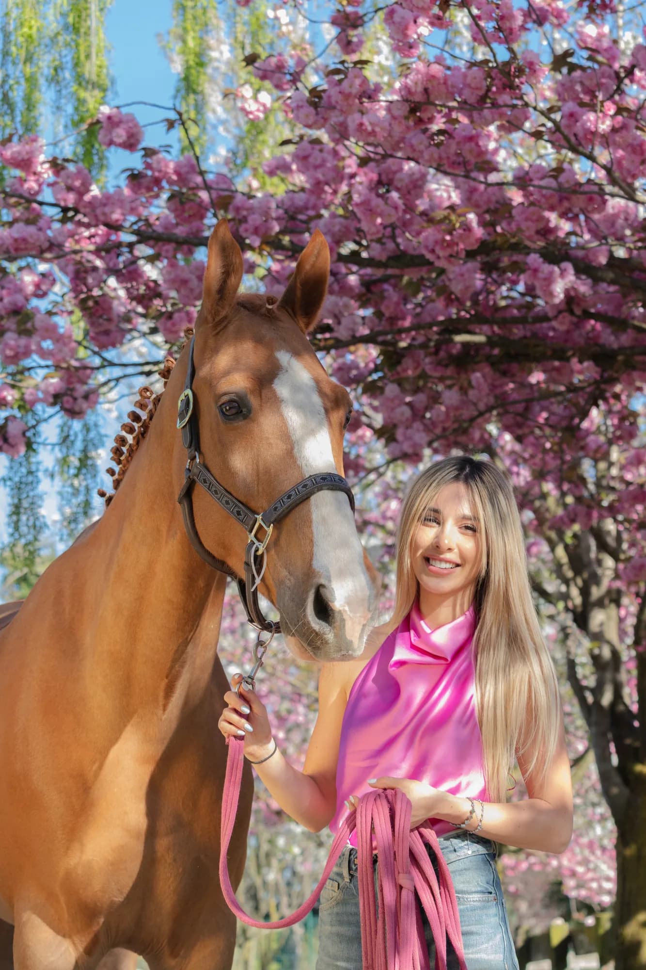 Rebecca, responsabile di Vintage d'Harmonie, ritratta con un cavallo e fiori di ciliegio